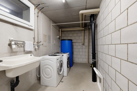 buanderie avec inside property, chauffe-eau, buanderie, sol en béton, et concrete floor
