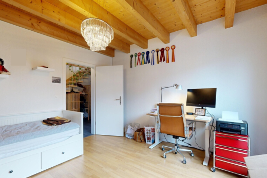 büro mit bürobereich, fernseher, holzfußboden, wood finish floor, und inside property