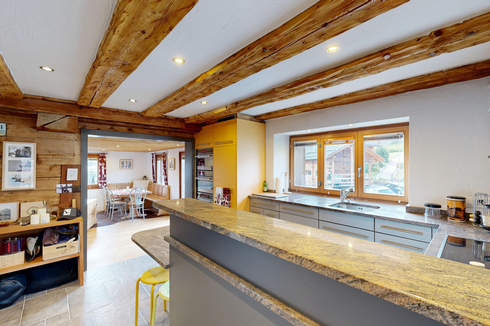 cuisine avec éclairage encastré, beamed ceiling, light floor, stone countertops, et plans de travail en pierre