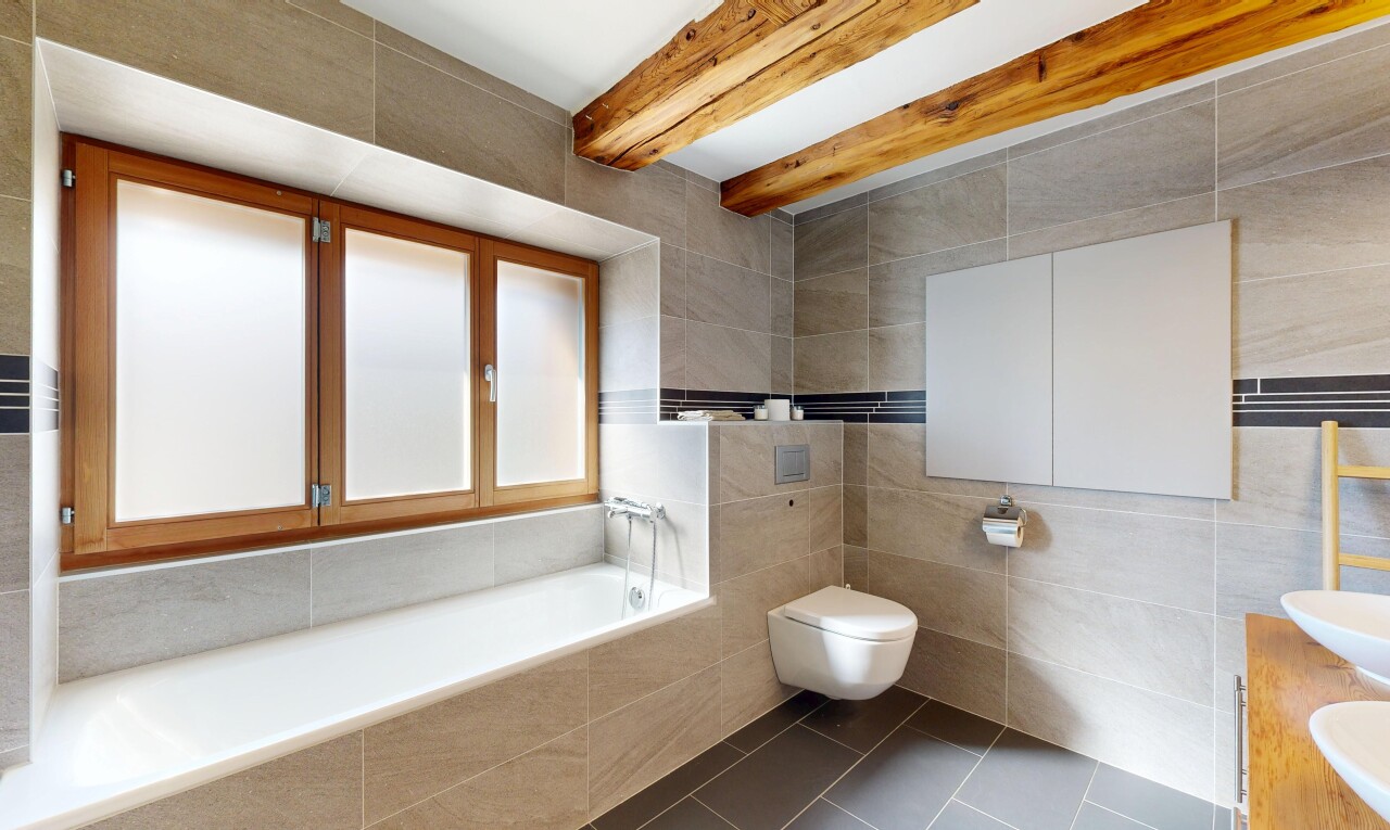 salle de bains avec salle de bain complète, tile wall, mur en carrelage, beamed ceiling, et plafond à poutres