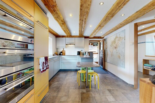 kitchen featuring stainless steel double oven, beam ceiling, recessed lighting, and light countertops
