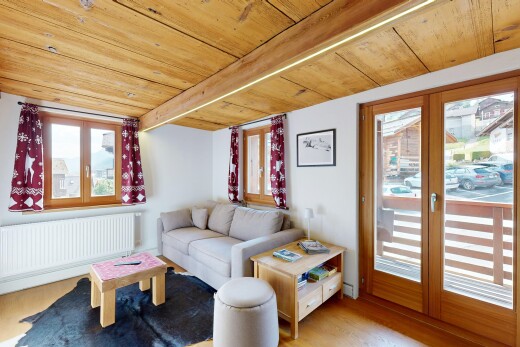 living area featuring a wood ceiling with exposed beams, radiator heating unit, and light wood-type flooring