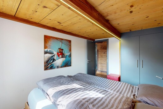 room with a wood ceiling with exposed beams and a closet