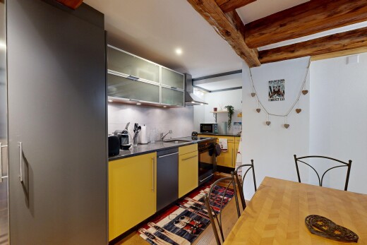 kitchen with beamed ceiling, glass insert cabinets, recessed lighting, and black appliances