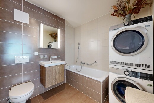salle de bains avec mur en carrelage, tile wall, tile tub, lavabo (ou coiffeuse selon le contexte), et sol en carrelage