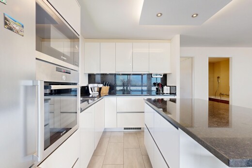 cuisine avec micro-ondes, réfrigérateur, armoires à panneau plat, sol en carrelage, et tile floor