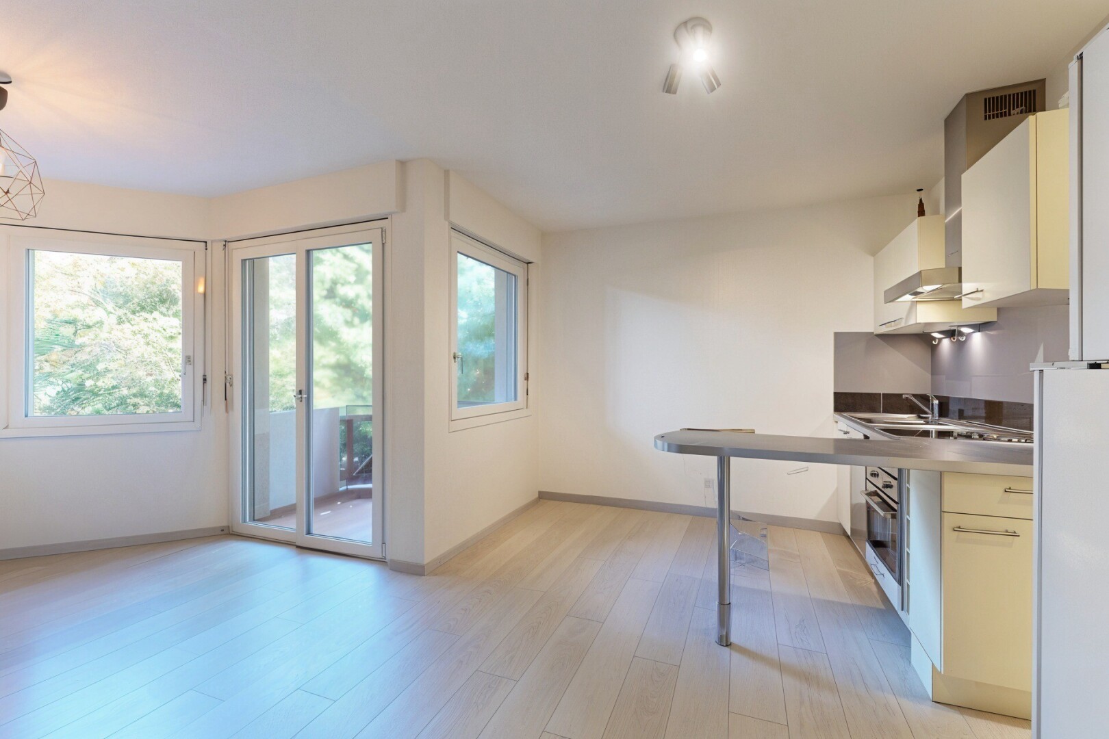 kitchen featuring light wood-style floors, wall chimney range hood, white cabinets, oven, and freestanding refrigerator