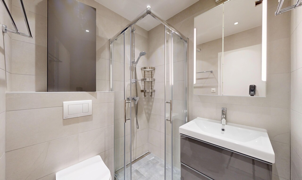 full bathroom with vanity, a stall shower, and tile walls