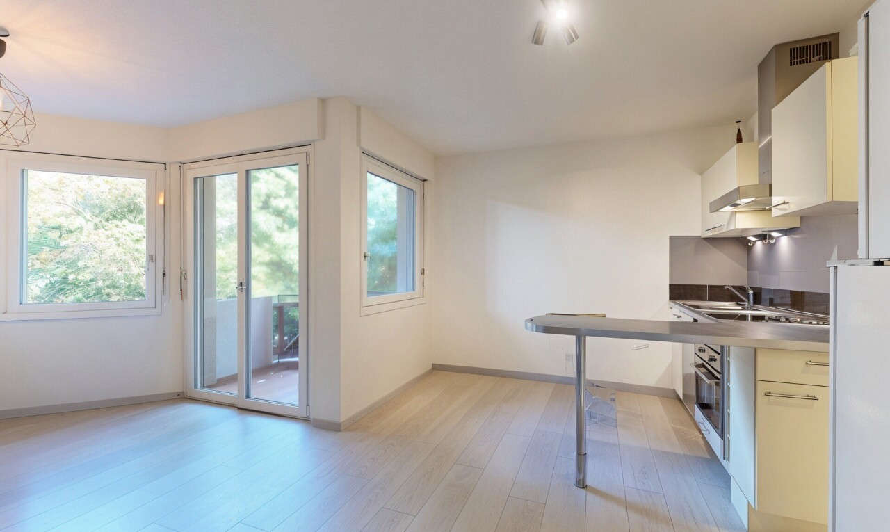 kitchen featuring light wood-style floors, wall chimney range hood, white cabinets, oven, and freestanding refrigerator