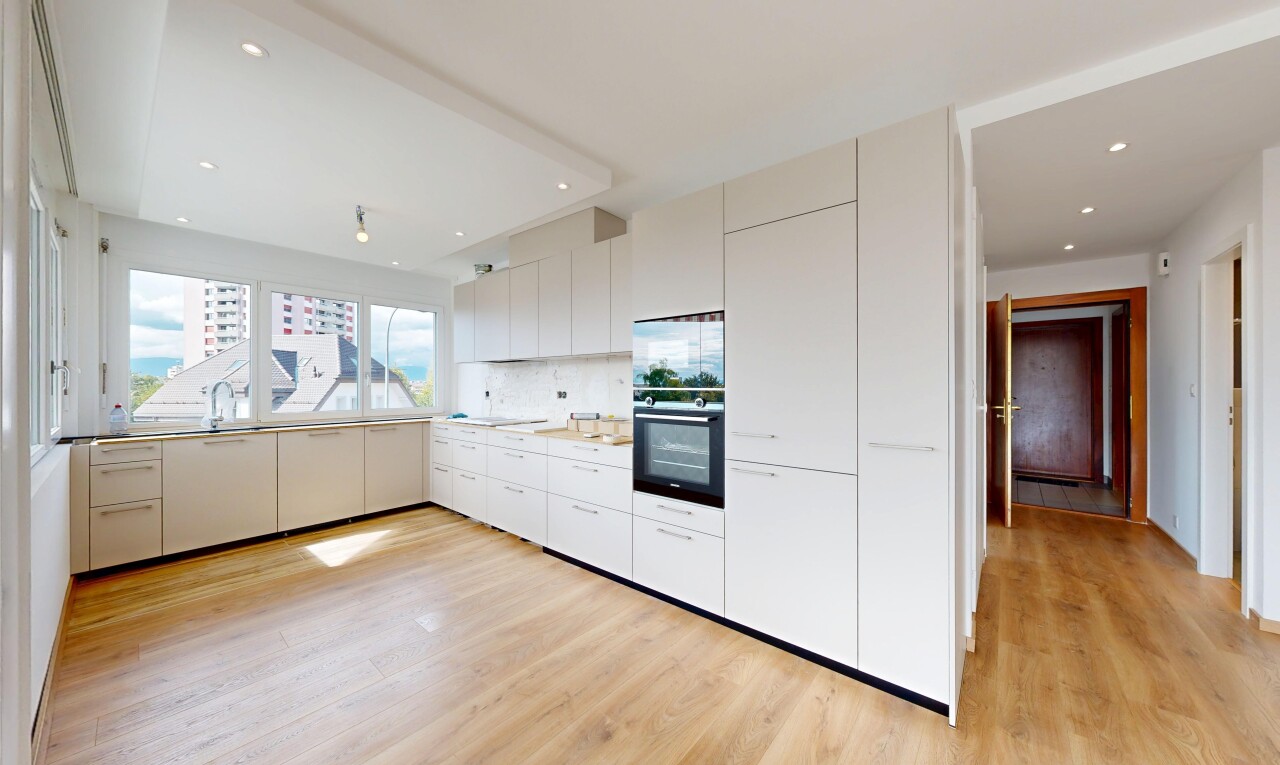 kitchen with modern cabinets, black oven, white cabinetry, light wood-type flooring, and light countertops