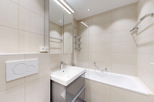 salle de bains avec mur en carrelage, tile wall, douche-bain combinés, lavabo (ou coiffeuse selon le contexte), et salle de bain complète