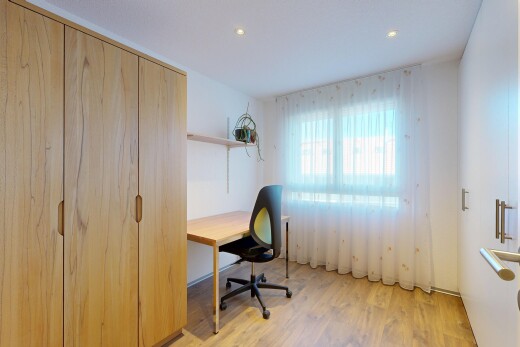chambre avec sol en finition bois, wood finish floor, espace bureau, lumière naturelle, et natural light