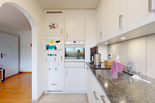 küche mit stein arbeitsplatten, ofen, gewölbte gehwege, inside property, und weiße schränke