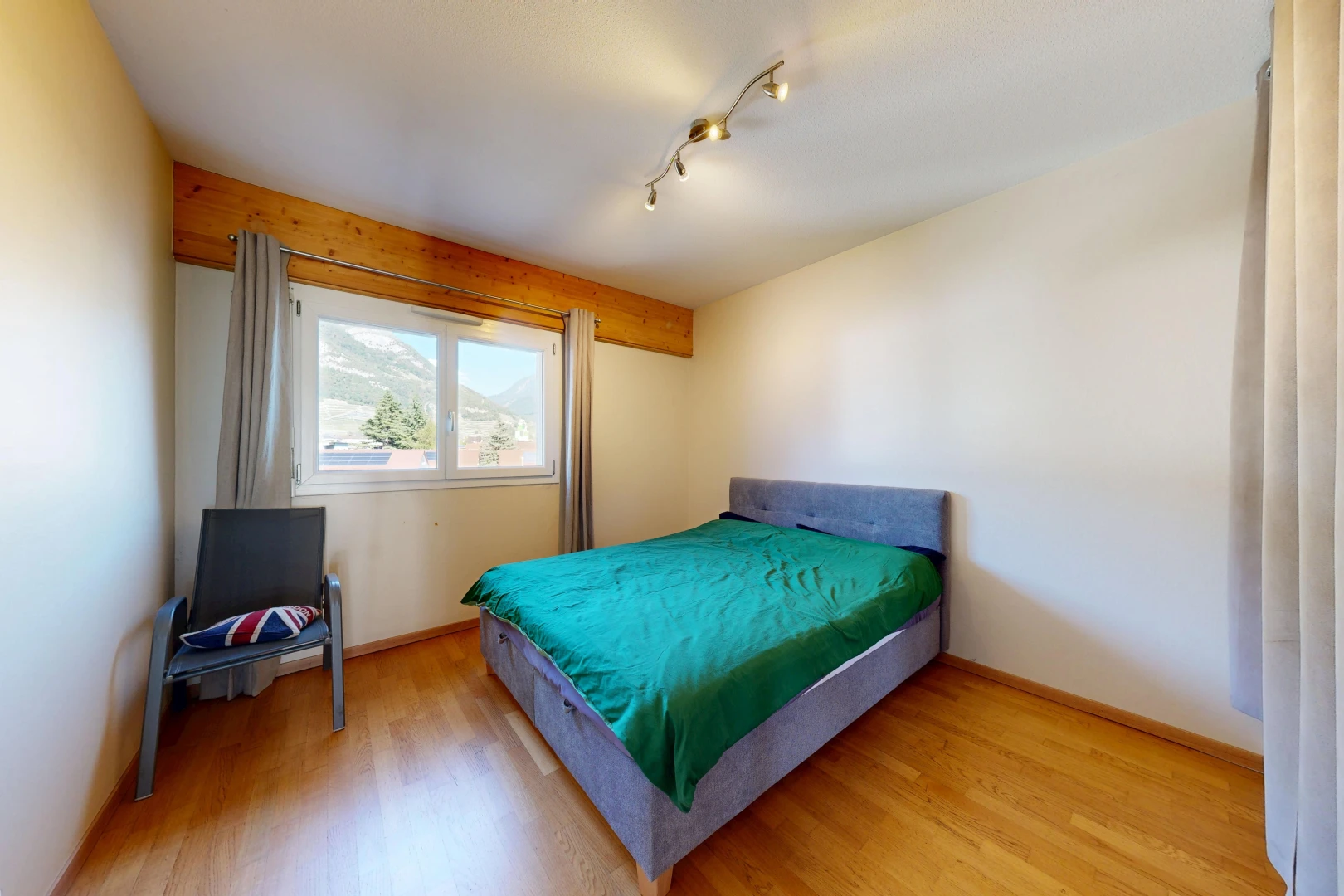 chambre avec éclairage sur rail, drywall, cloison sèche, wood finish floor, et sol en finition bois