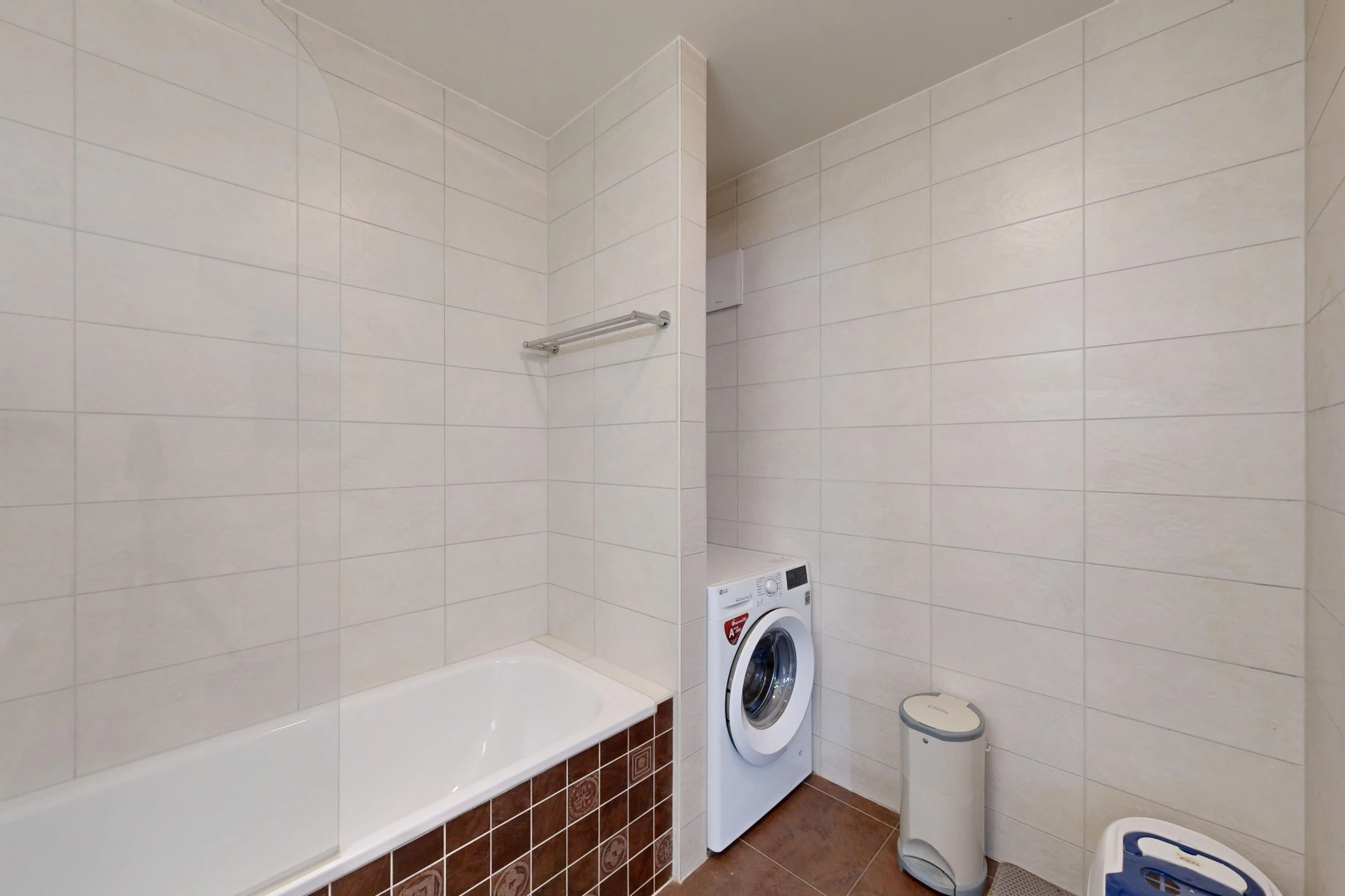 buanderie avec tile wall, mur en carrelage, tile floor, sol en carrelage, et lave-linge et sèche-linge