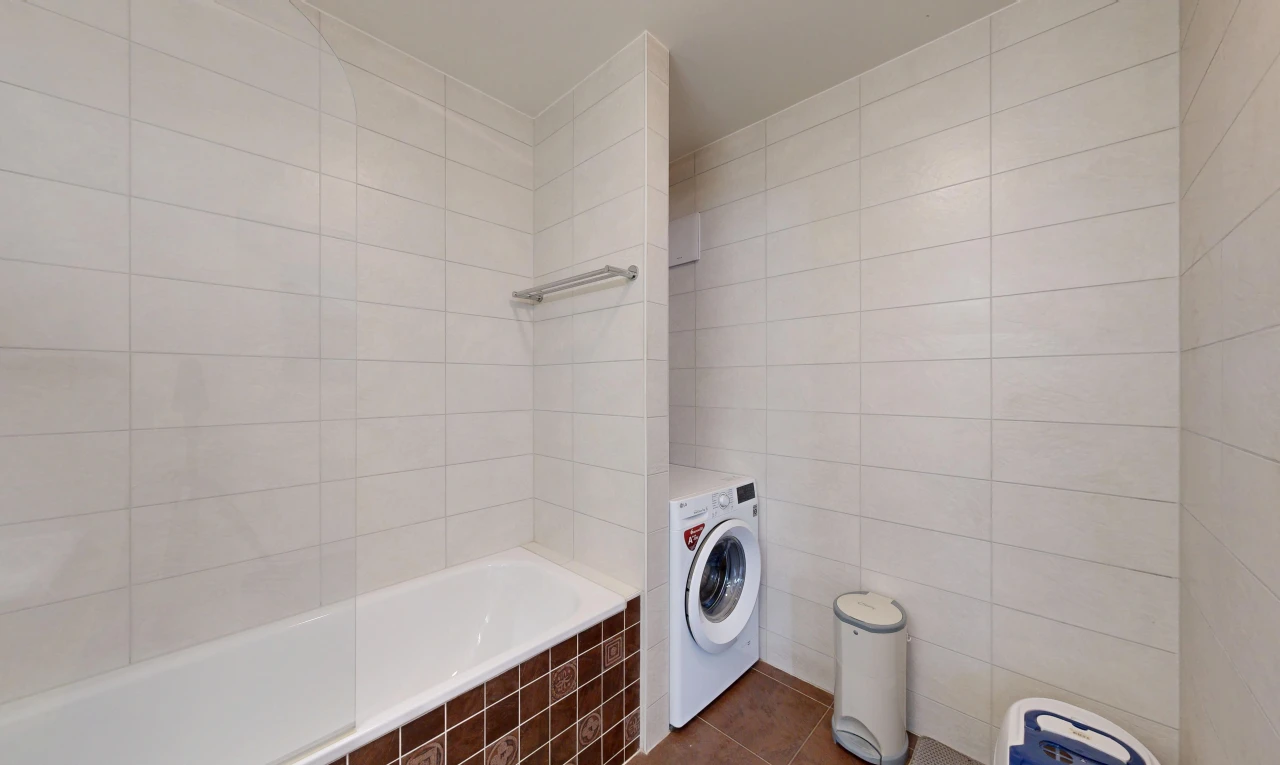 buanderie avec tile wall, mur en carrelage, tile floor, sol en carrelage, et lave-linge et sèche-linge