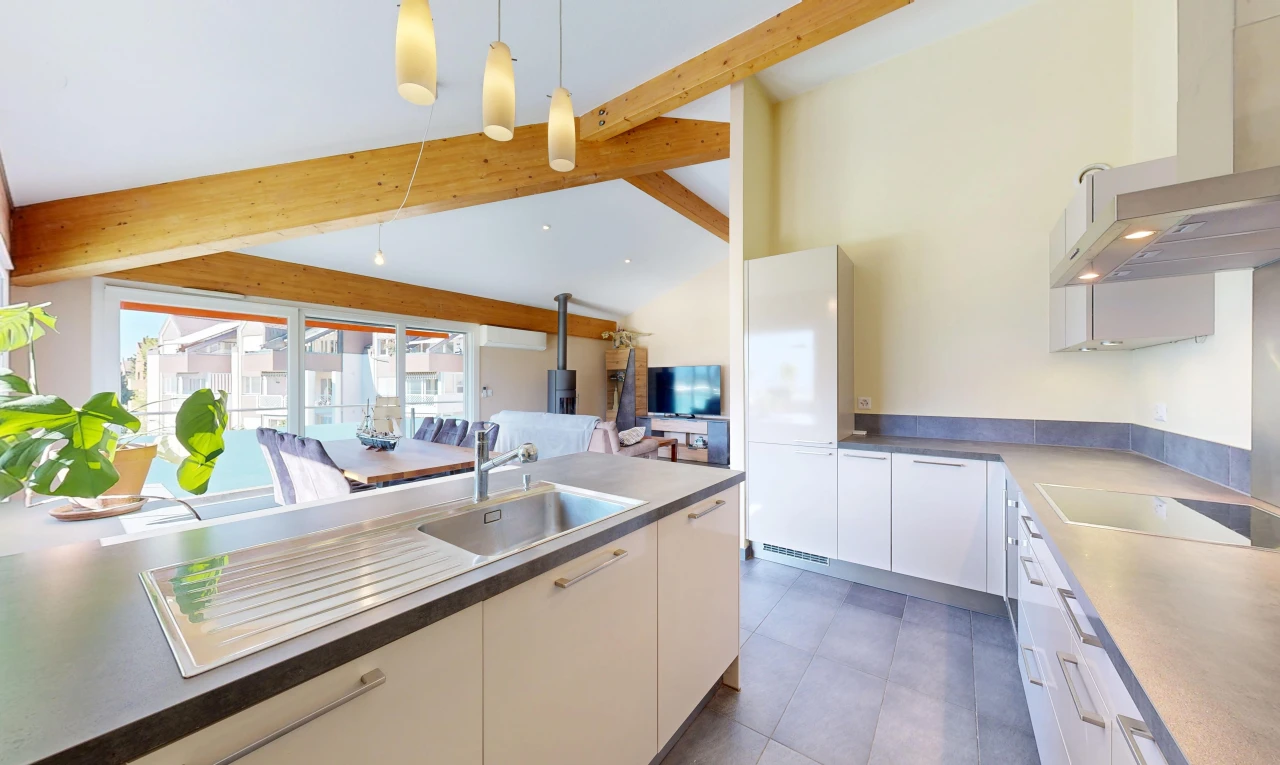 cuisine avec hotte, évier, télévision, high end ceiling, et éclairage suspendu