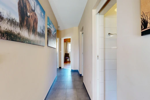 couloir avec inside property, cloison sèche, drywall, plinthes murales, et baseboards wall