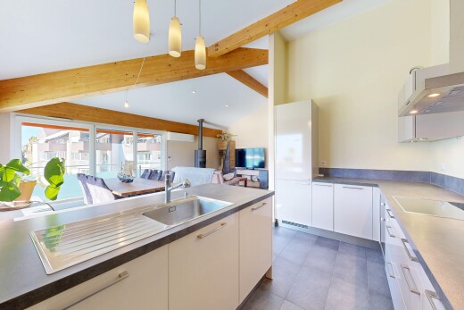 cuisine avec hotte, évier, télévision, high end ceiling, et éclairage suspendu
