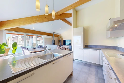 cuisine avec hotte, évier, télévision, high end ceiling, et éclairage suspendu