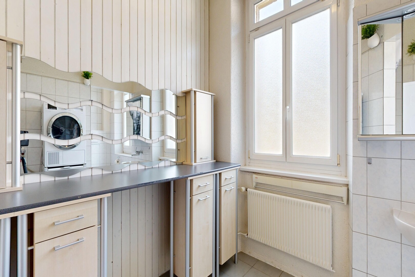 cuisine avec radiateur, inside property, lave-linge et sèche-linge, lumière naturelle, et natural light