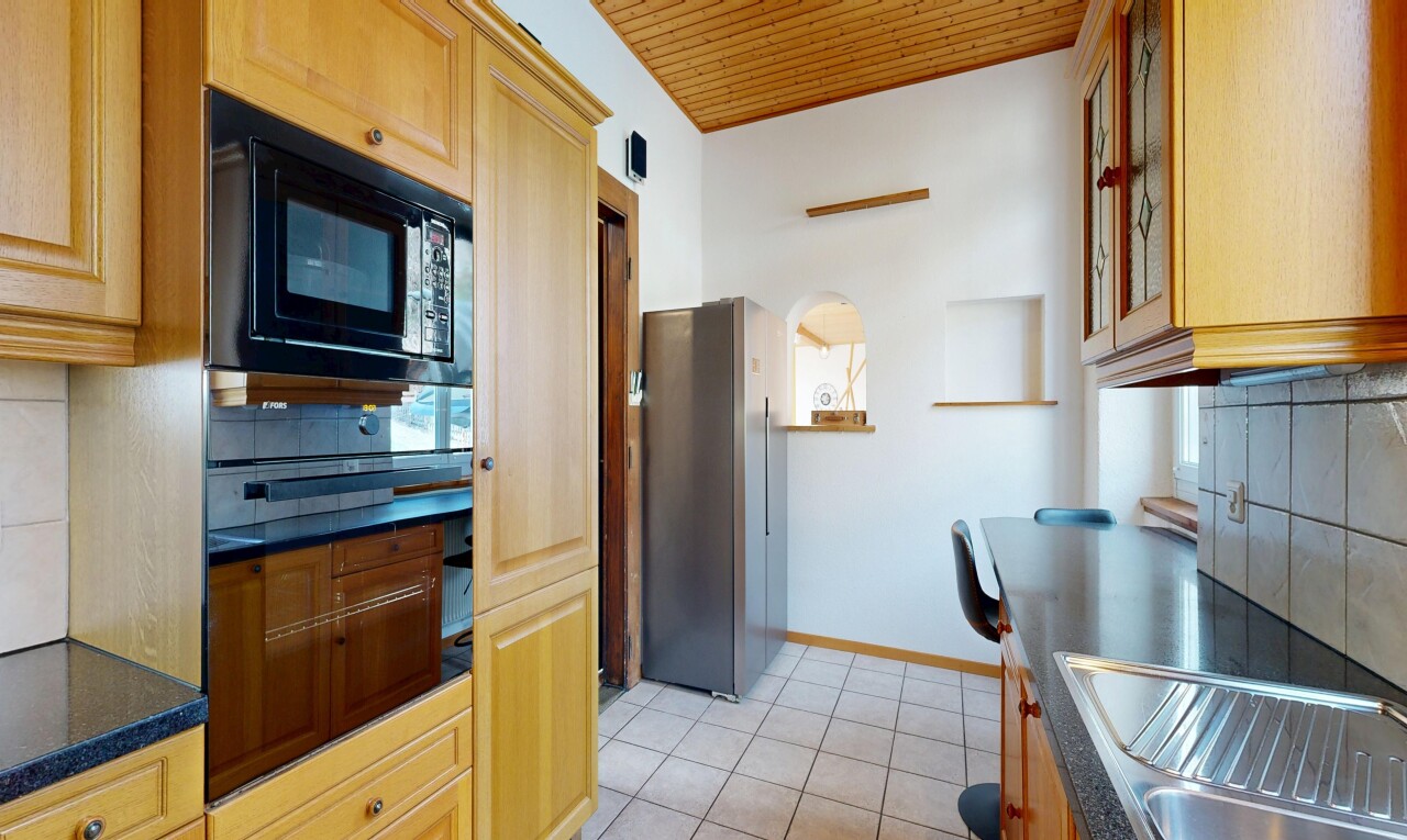 cuisine avec dosseret, backsplash, plans de travail, dark countertops, et réfrigérateur