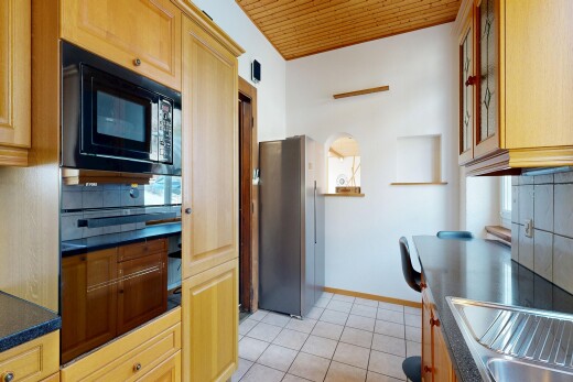 cuisine avec dosseret, backsplash, plans de travail, dark countertops, et réfrigérateur