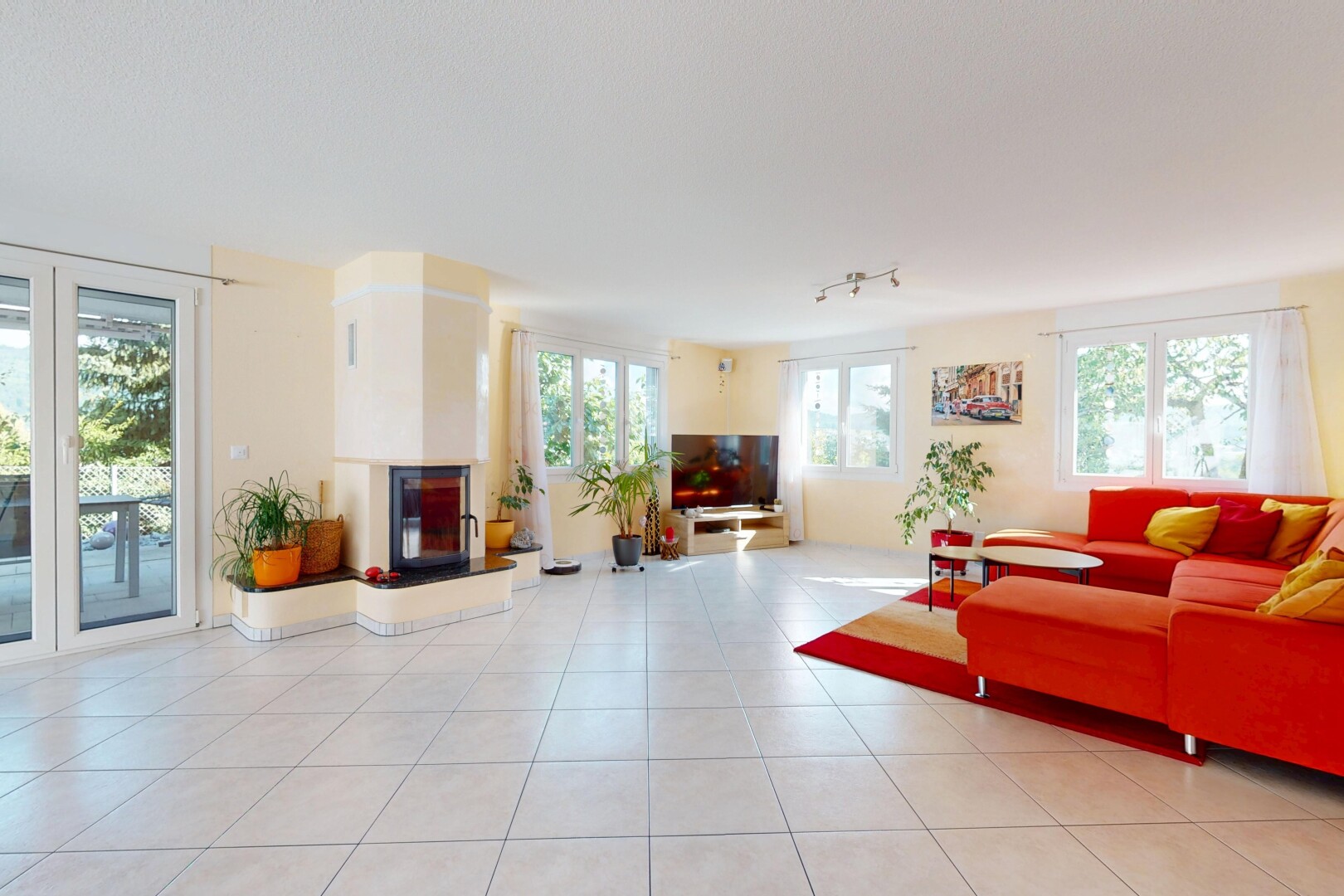 wohnzimmer mit inside property, fernseher, natürliches licht, natural light, und fliesenboden