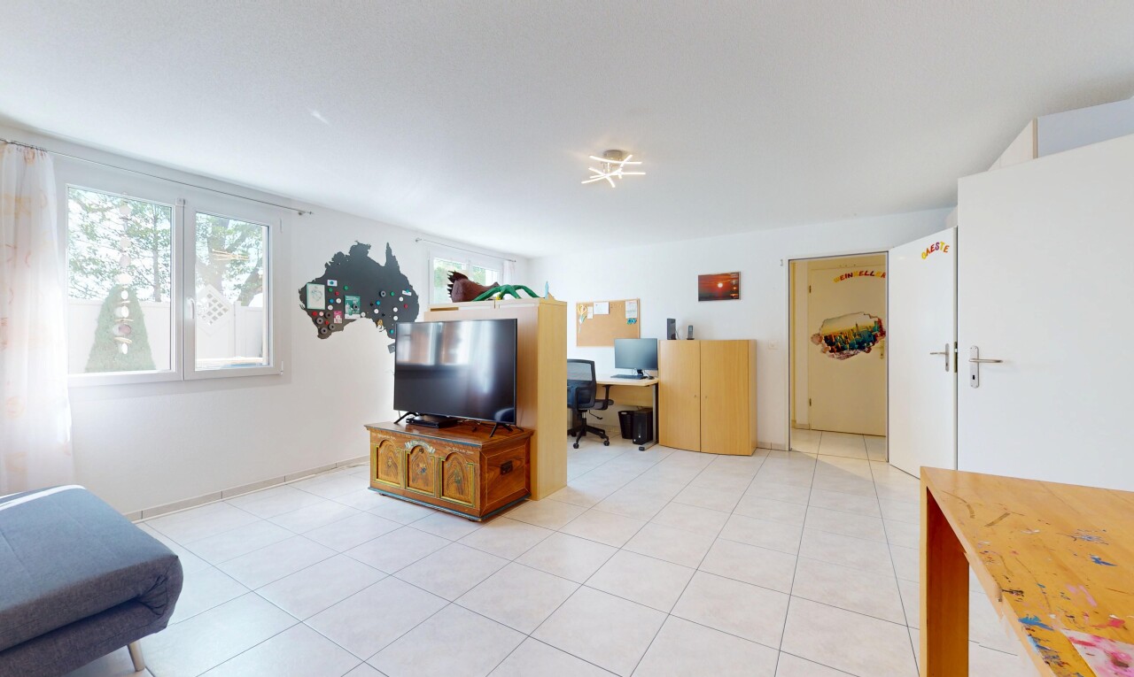 wohnzimmer mit natural light, natürliches licht, bürobereich, fernseher, und inside property