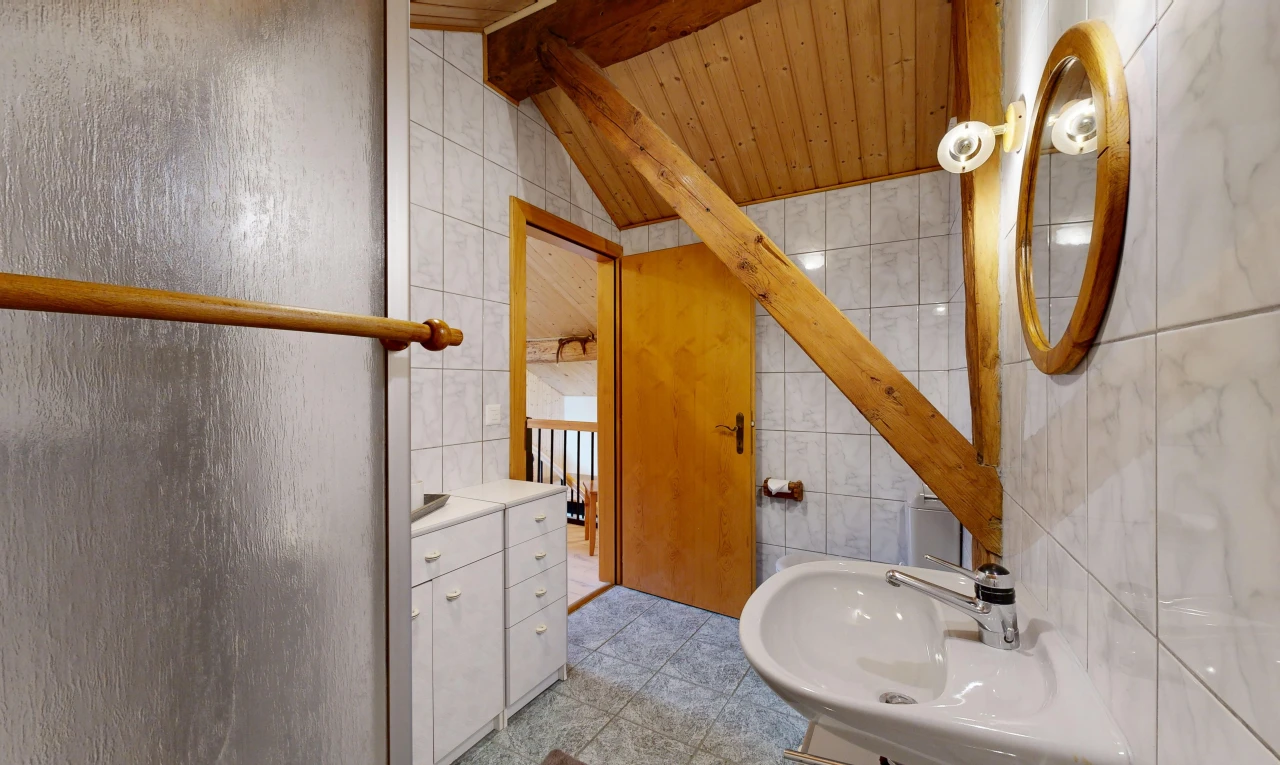 salle de bains avec mur en carrelage, tile wall, plafond voûté, vaulted ceiling, et évier