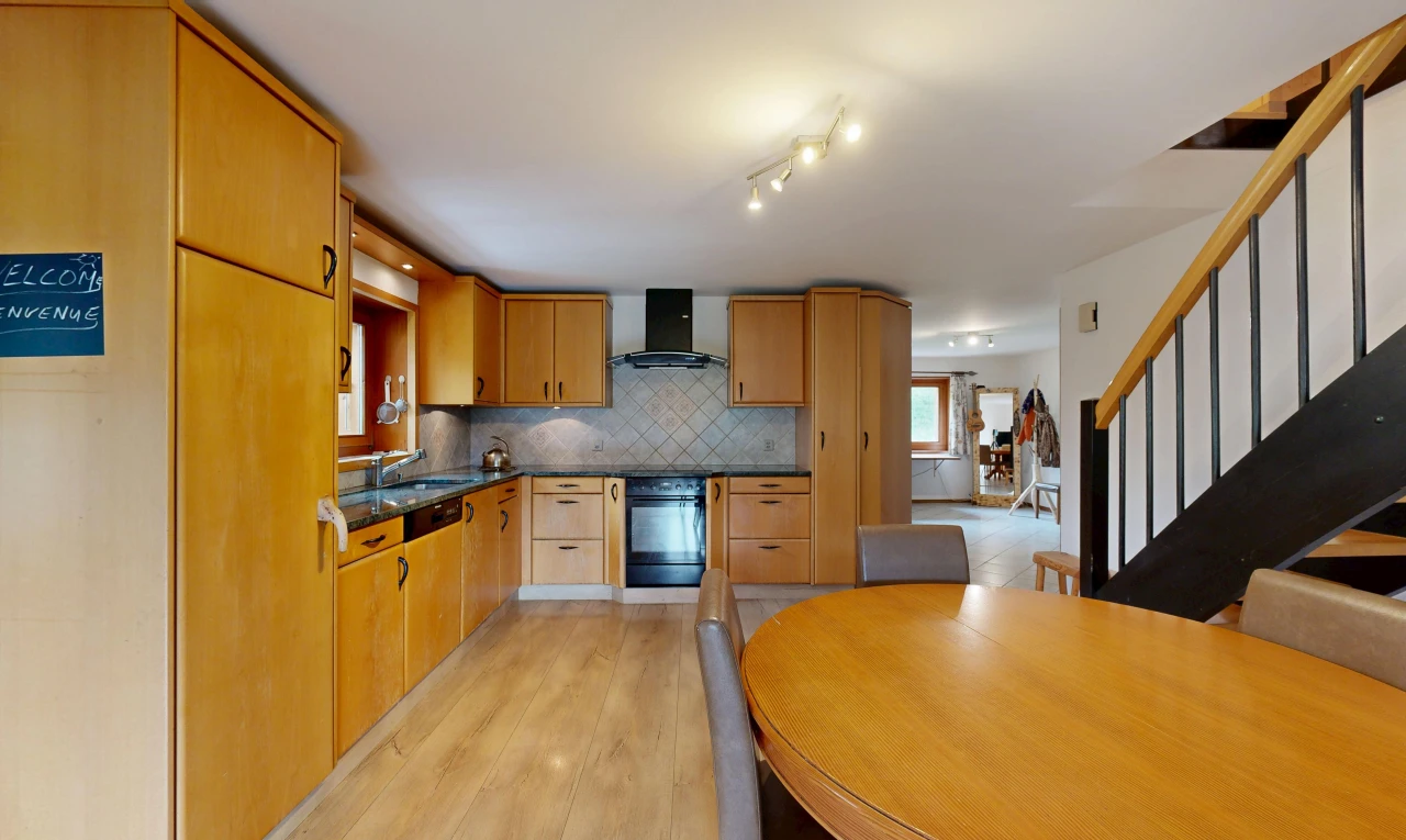 cuisine avec dark countertops, escaliers, light floor, hotte, et four