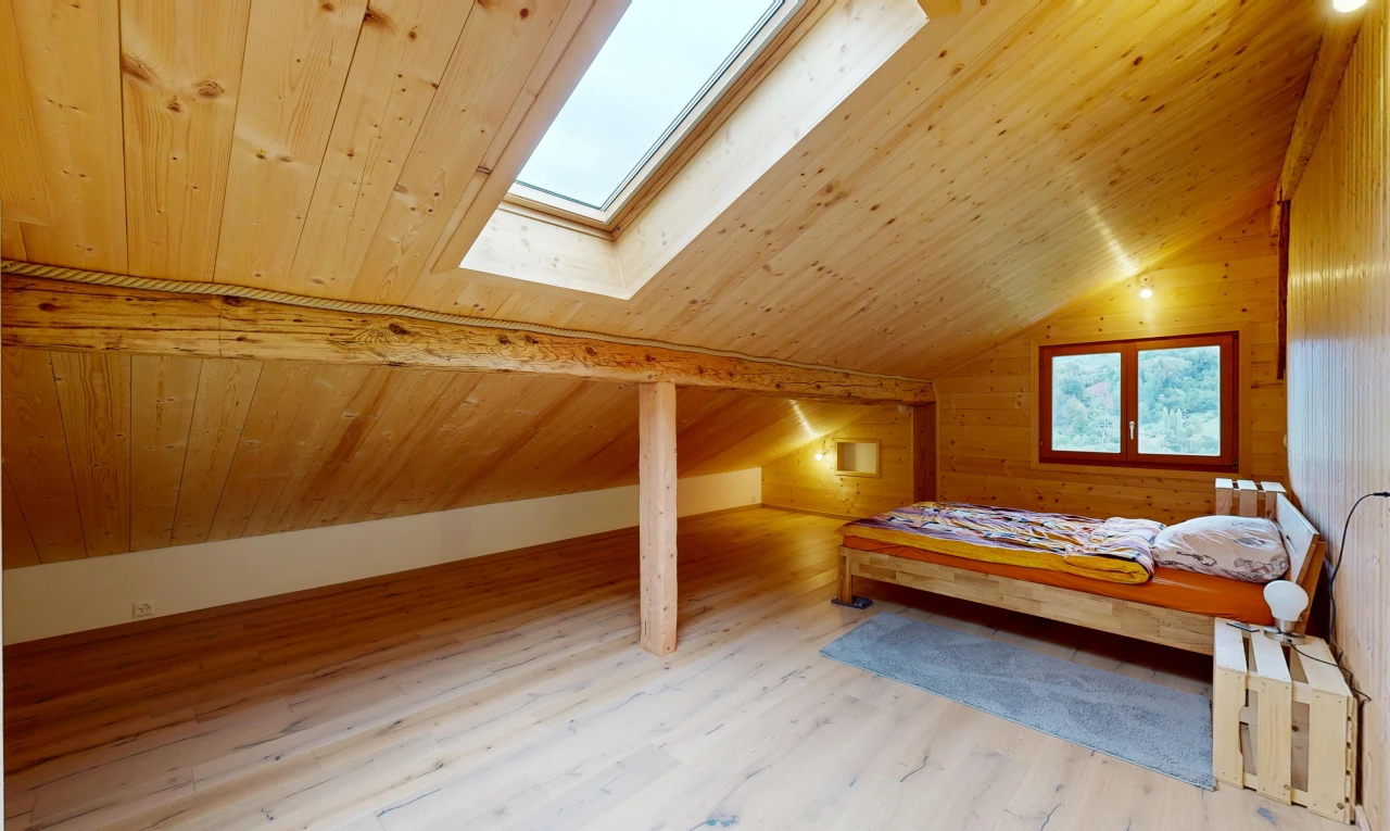 chambre avec puits de lumière, sol en finition bois, wood finish floor, plafond voûté, et vaulted ceiling