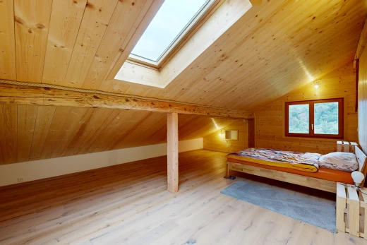 chambre avec puits de lumière, sol en finition bois, wood finish floor, plafond voûté, et vaulted ceiling