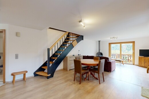 wohn- / esszimmer mit holzofen, treppen, gipskartonwand, drywall, und wood finish stairs