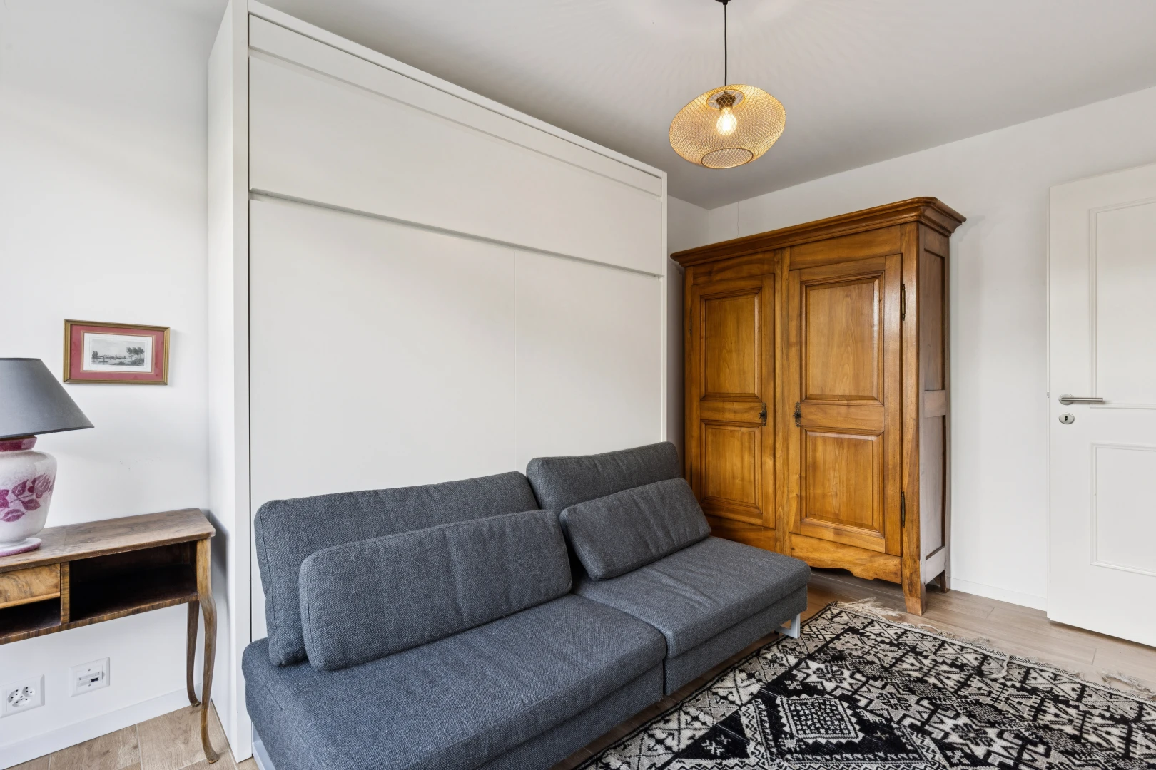 salon avec drywall, cloison sèche, éclairage suspendu, wood finish floor, et sol en finition bois