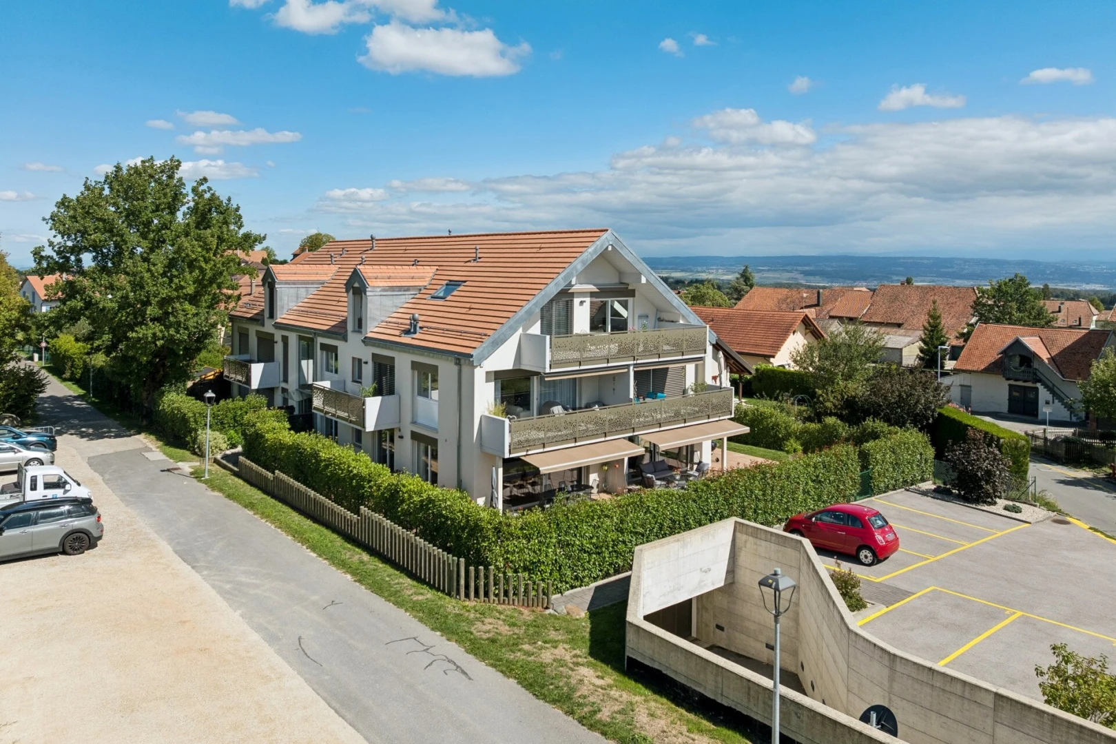 façade avec drone view, day time, parking, et toit en tuiles