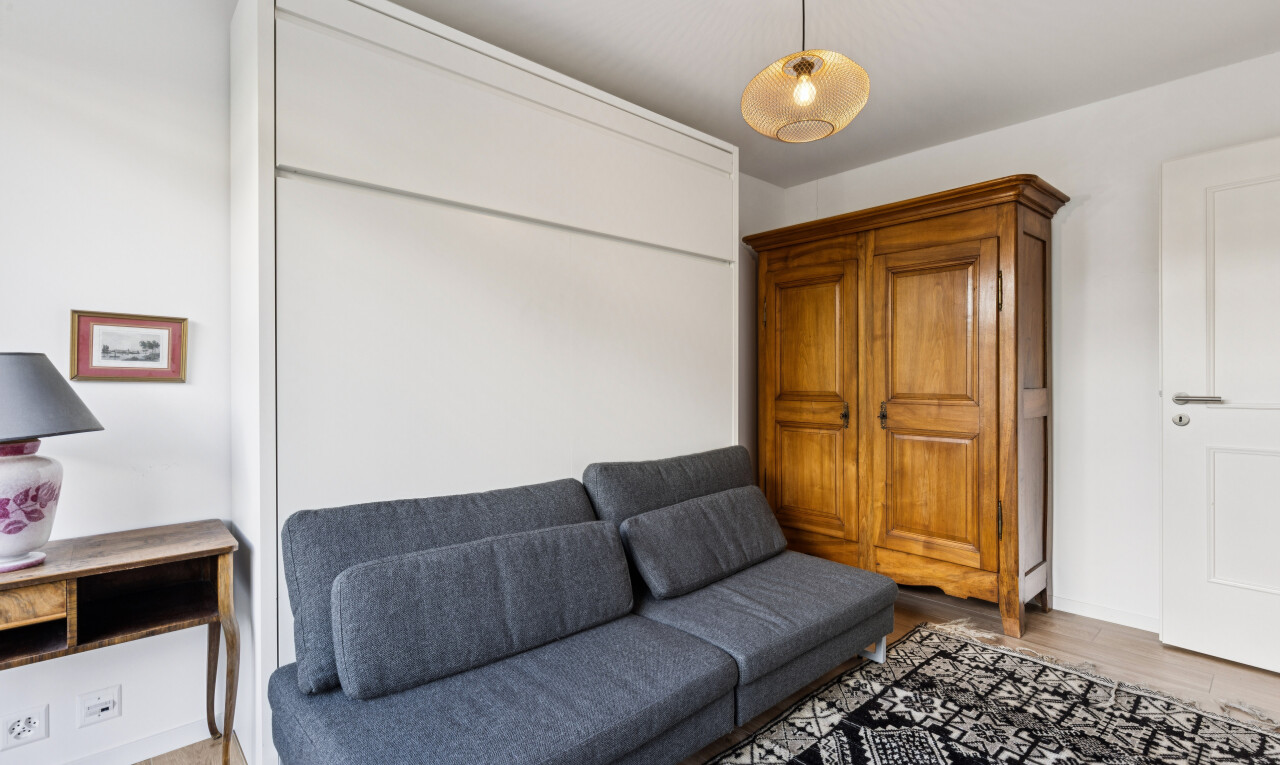 salon avec drywall, cloison sèche, éclairage suspendu, wood finish floor, et sol en finition bois