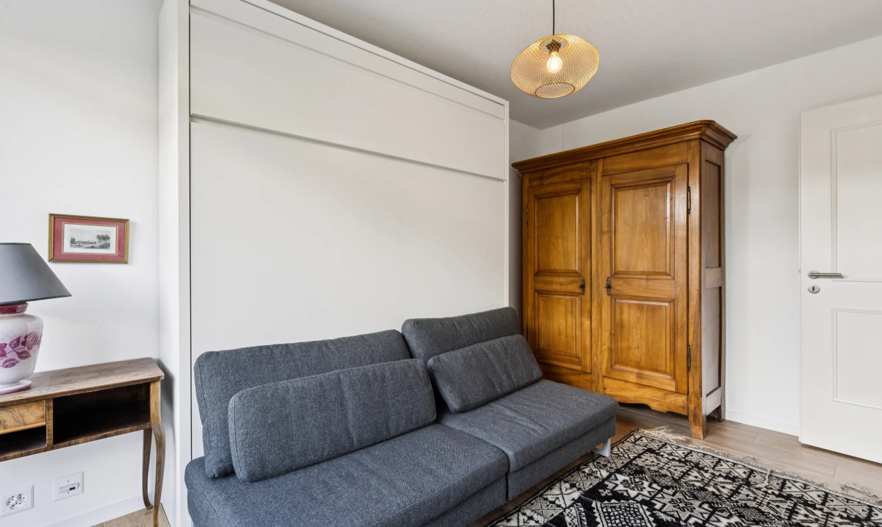 salon avec drywall, cloison sèche, éclairage suspendu, wood finish floor, et sol en finition bois