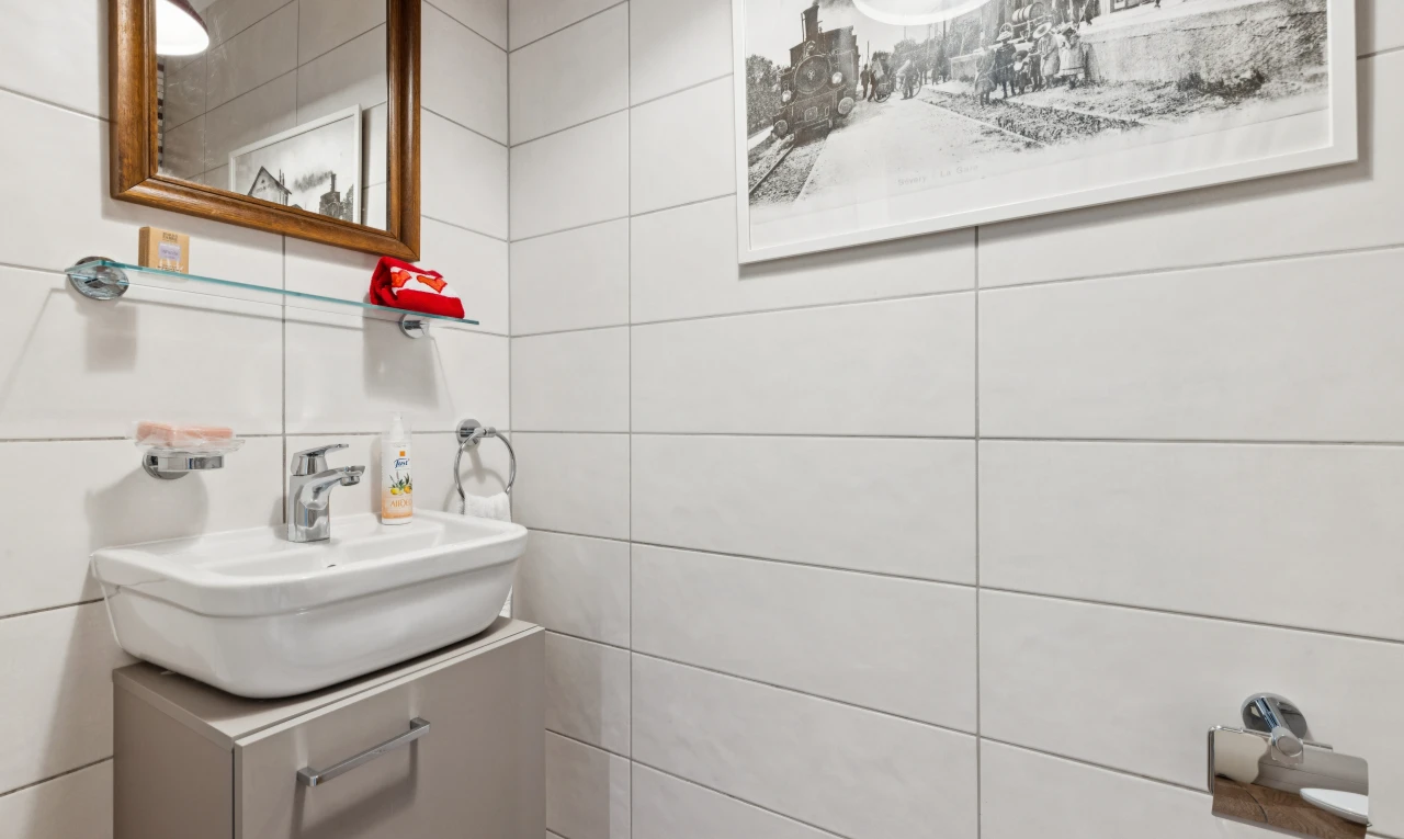 salle de bains avec miroir, évier, lavabo (ou coiffeuse selon le contexte), inside property, et tile wall