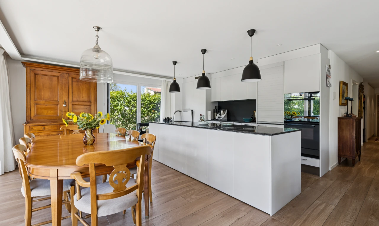 cuisine avec éclairage suspendu, dark countertops, plans de travail, four double, et wood finish floor