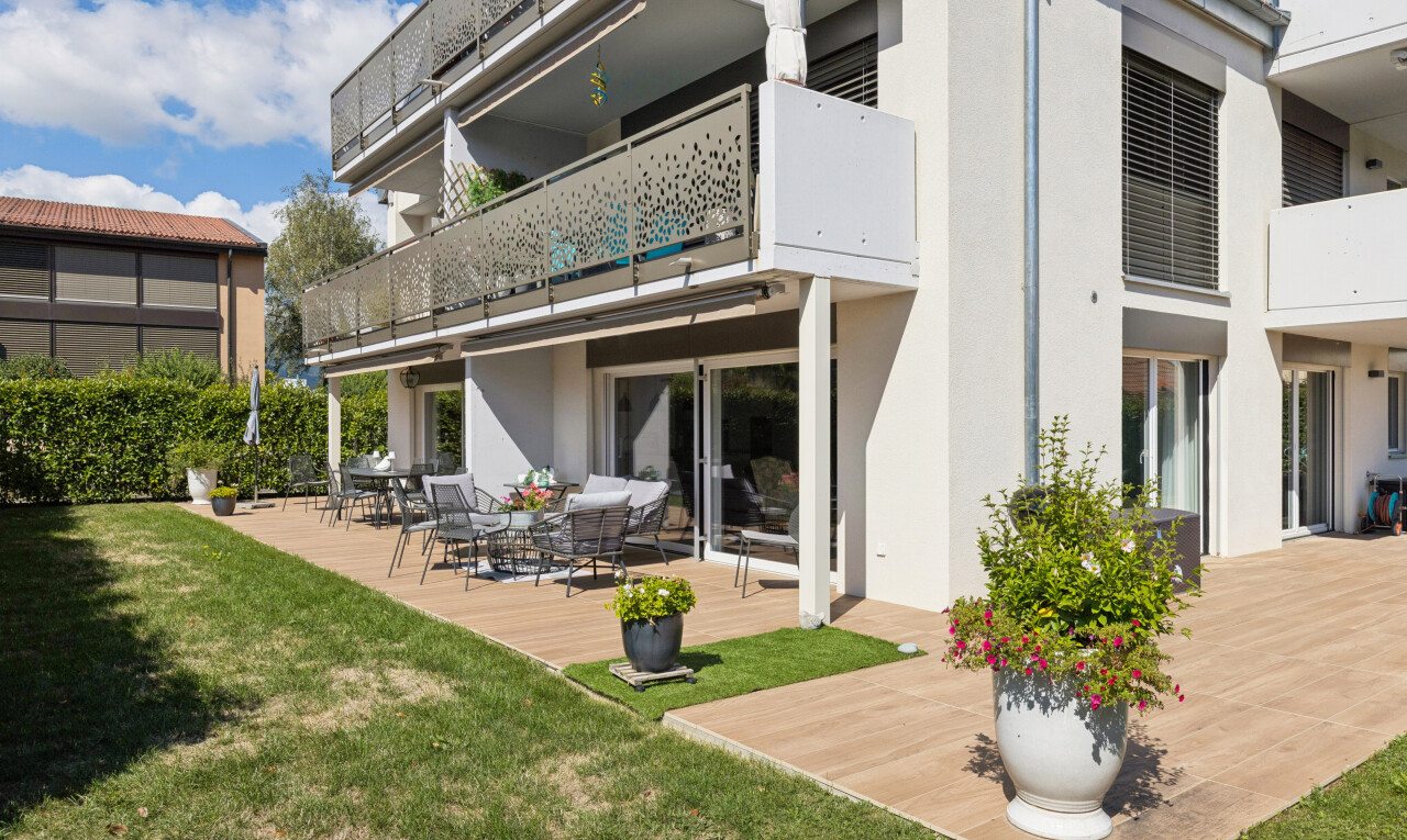 façade avec balcon, terrasse, pelouse, bardage en stuc, et day time