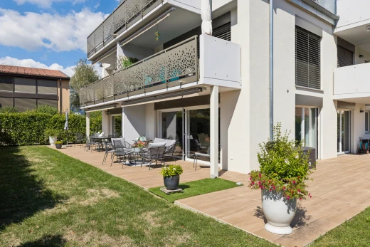 façade avec balcon, terrasse, pelouse, bardage en stuc, et day time