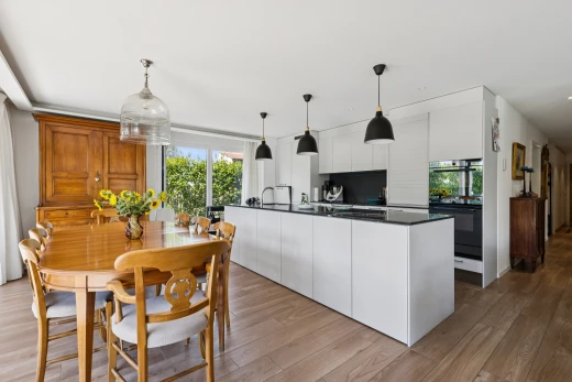 cuisine avec éclairage suspendu, dark countertops, plans de travail, four double, et wood finish floor