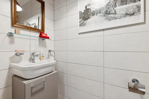 salle de bains avec miroir, évier, lavabo (ou coiffeuse selon le contexte), inside property, et tile wall