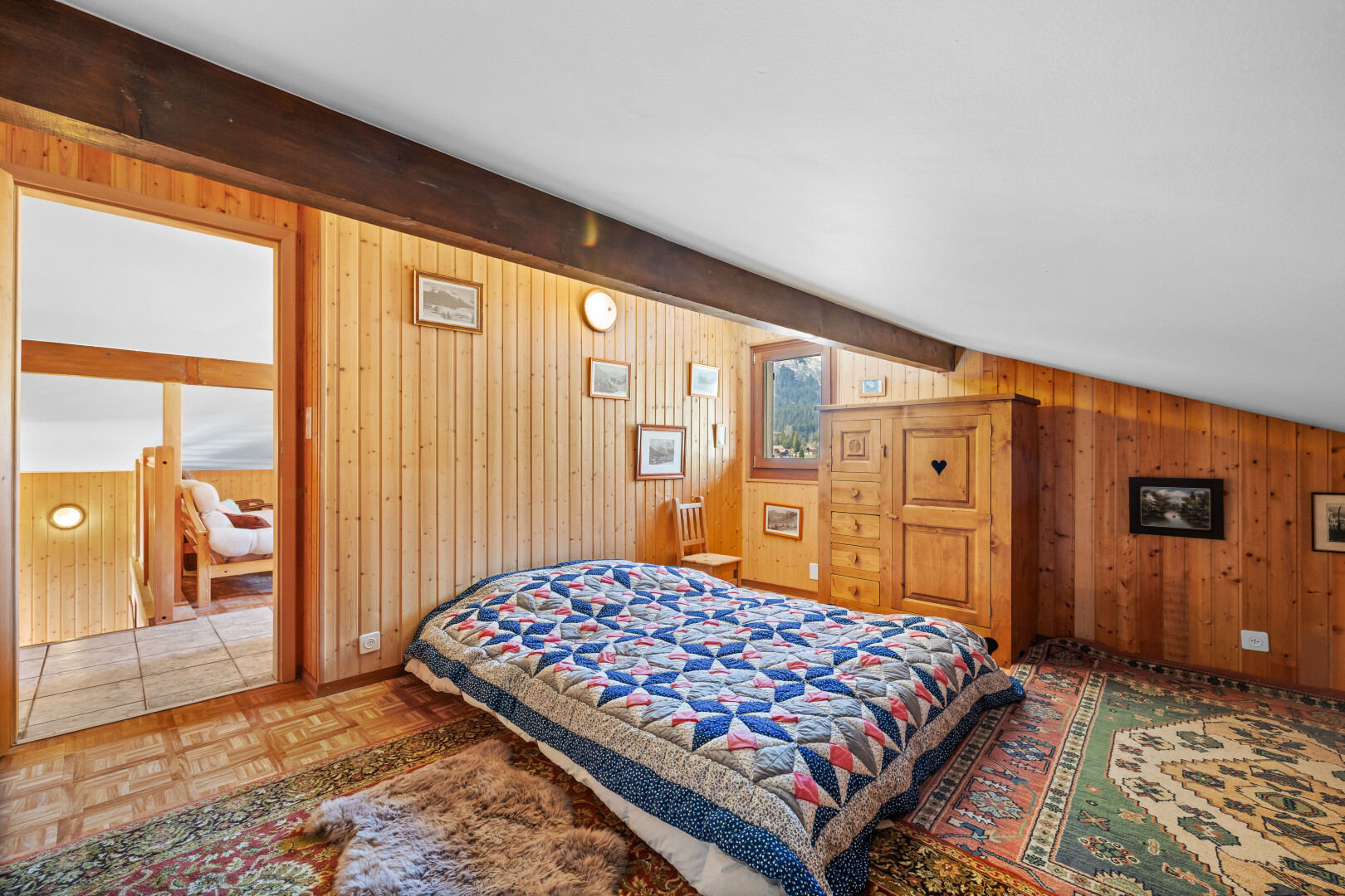 chambre avec beamed ceiling, plafond à poutres, parquet floor, wood wall, et mur en bois