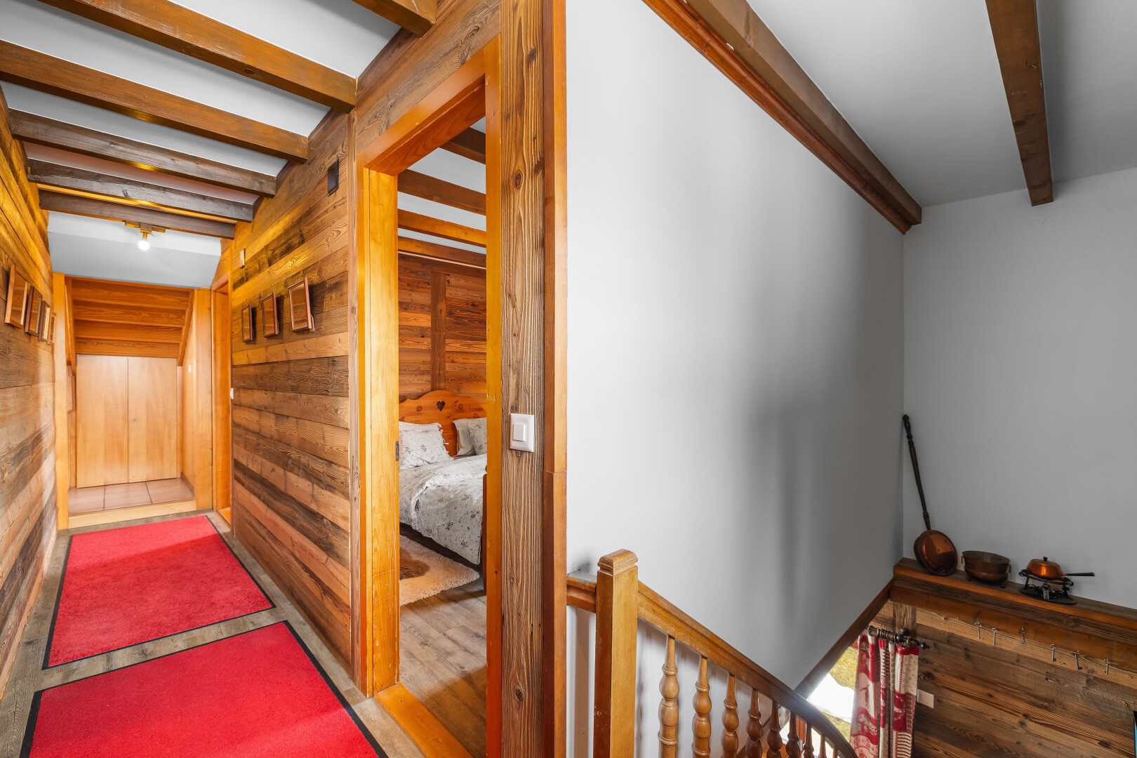 escaliers avec plafond à poutres, beamed ceiling, inside property, mur en bois, et wood wall