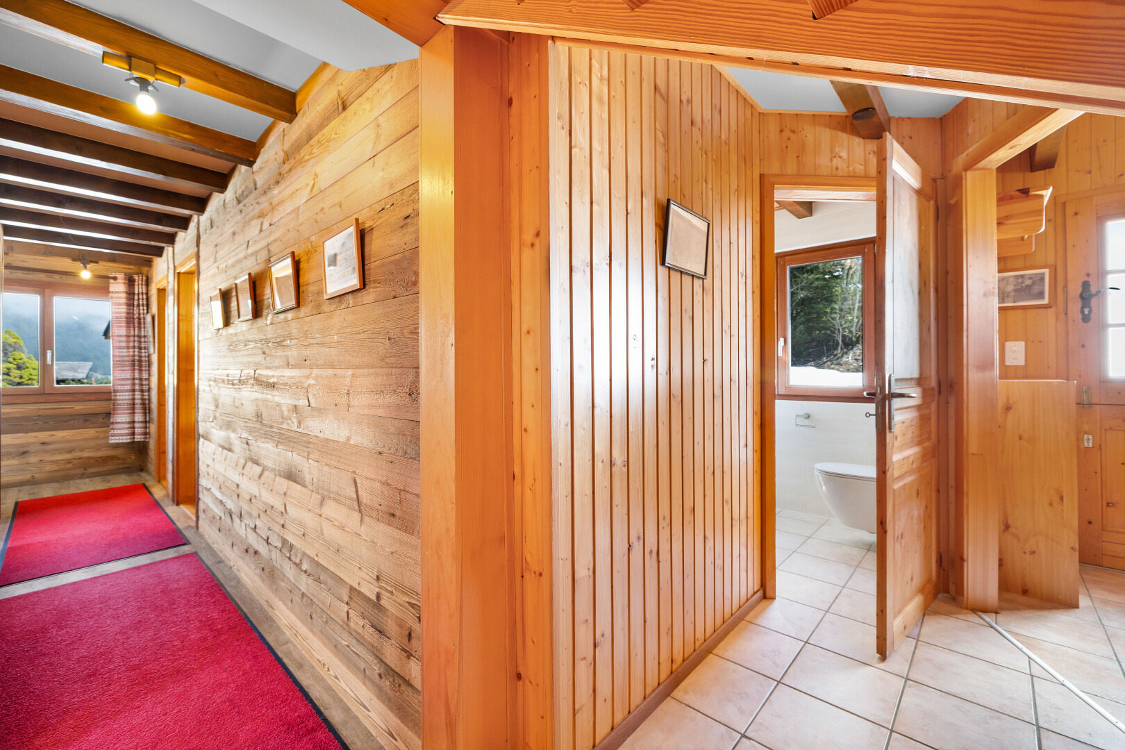 couloir avec mur en bois, wood wall, plafond à poutres, beamed ceiling, et lumière naturelle