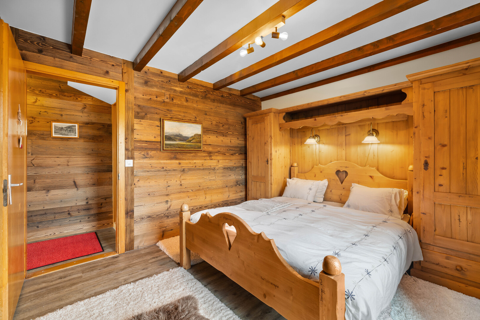 chambre avec mur en bois, wood wall, inside property, plafond à poutres, et beamed ceiling