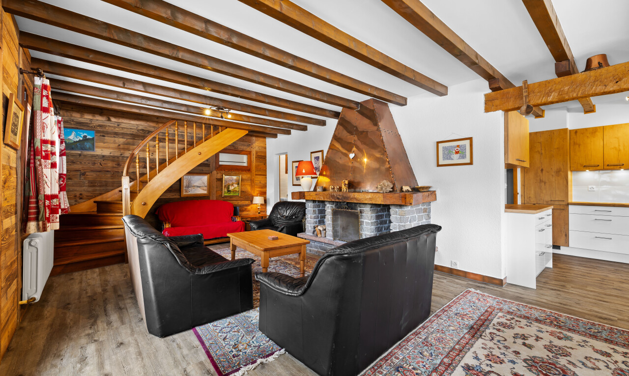 salon avec escaliers, inside property, wood finish floor, sol en finition bois, et beamed ceiling