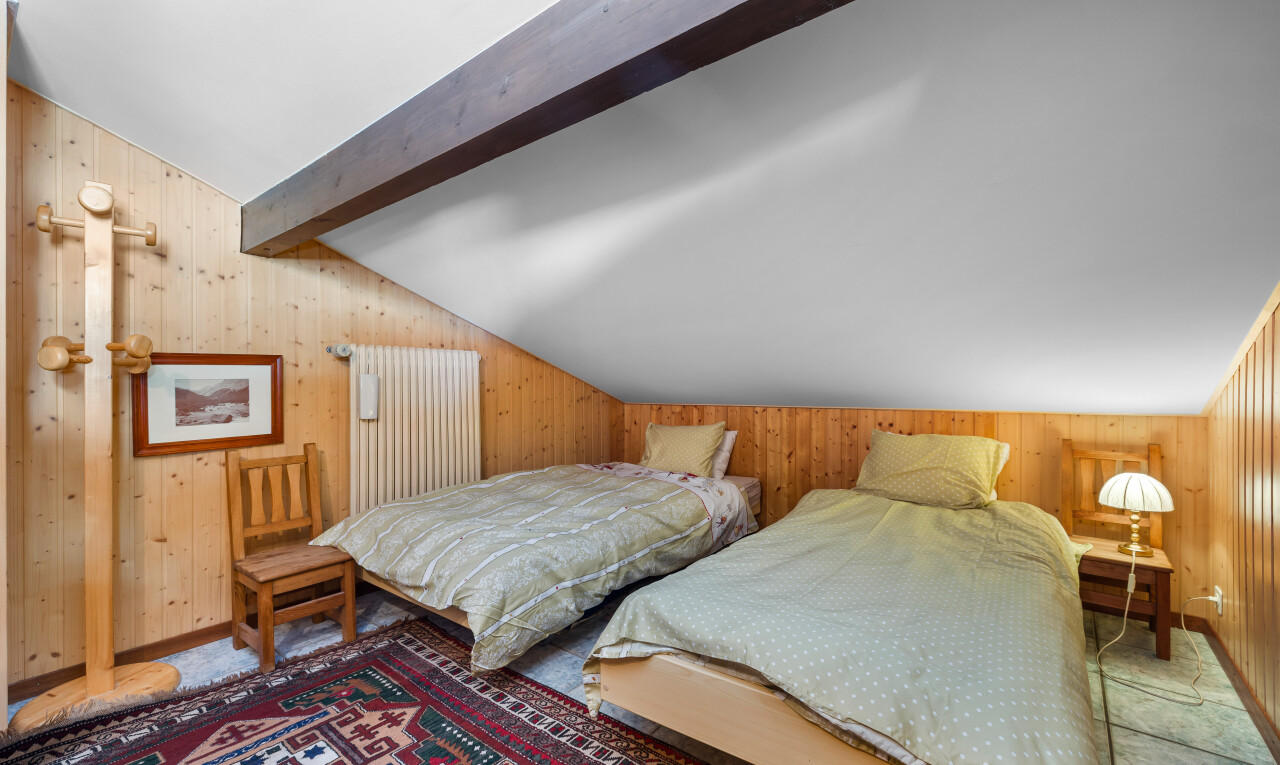 chambre avec vaulted ceiling, plafond voûté, wood wall, mur en bois, et beamed ceiling